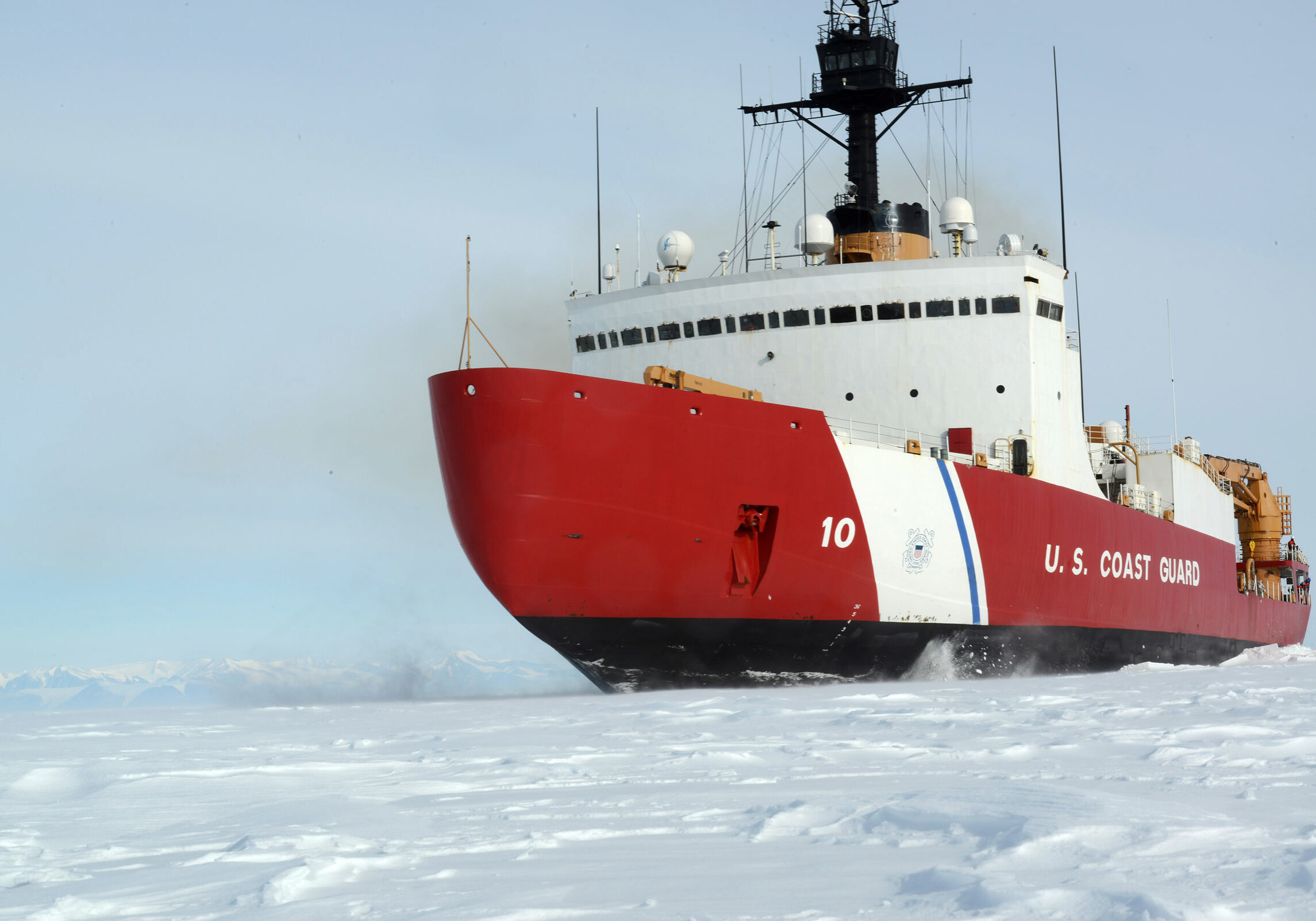 Red and white US Coast Guard boat on snowy waters