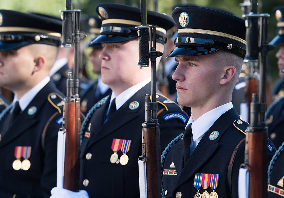 Honor Guard soldiers lined up holding rifles vertically